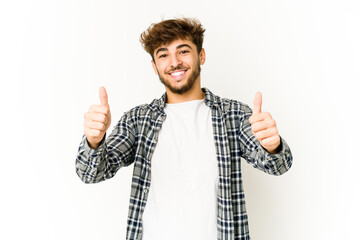 Naklejka premium Young arab man on white background smiling and raising thumb up