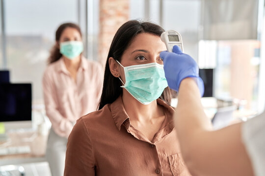 Employees going through mandatory temperature checks in office, Poland, podkarpackie, D&fnof;&ocirc;bica