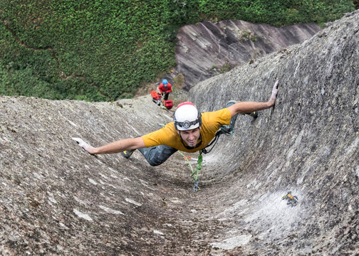 Male rock climber challenging steep wall of Pedra Baiana