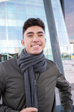 Smiling young in warm clothing contemplating in city