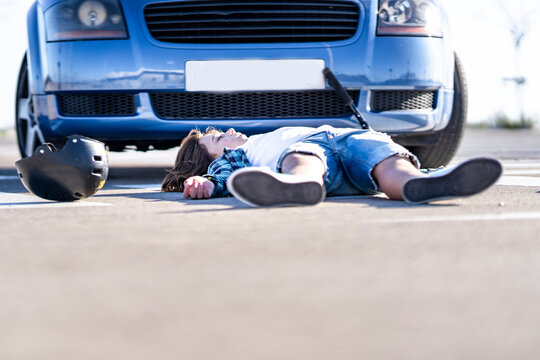 Unconscious boy lying on road after car accident