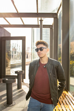 Young man wearing sunglasses looking away while standing in lobby