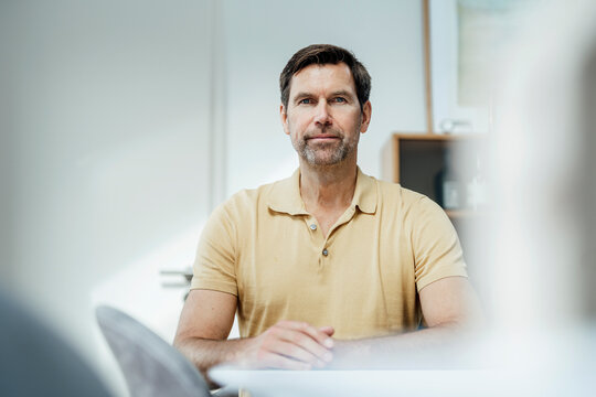 Mature man with blank expression at home