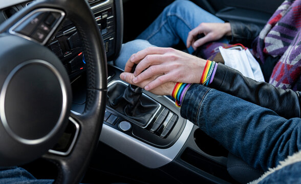 Hands of gay boyfriends holding gearshift in car