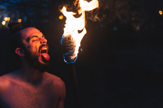 Male Juggler Performing With Fire Staff At Night