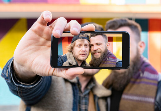 Close-up of gay couple taking selfie with mobile phone