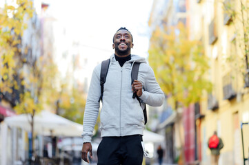 Man carrying backpack while walking in city