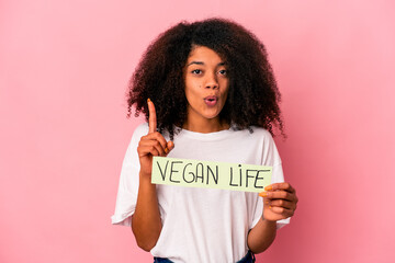 Young african american curly woman holding a vegan life placard having some great idea, concept of creativity.