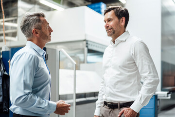 Business people having discussion while standing at industry