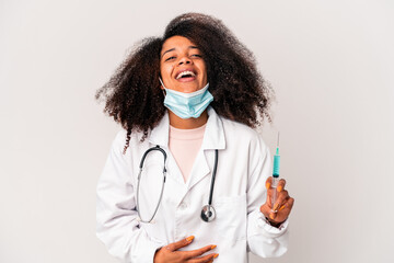 Young african american curly doctor woman holding a syringe laughing and having fun.