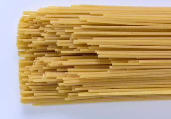 A closeup shot of spaghetti ends on a white background