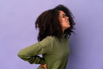 Young african american curly woman isolated on purple background suffering a back pain.