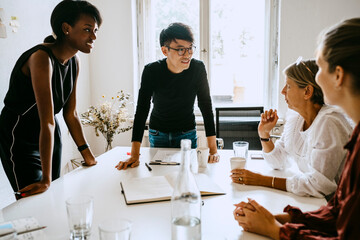 Businessman discussing with female colleagues during seminar in office