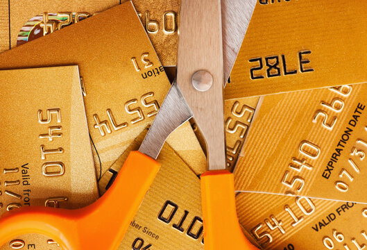 Scissors on pile of credit cards, studio shot