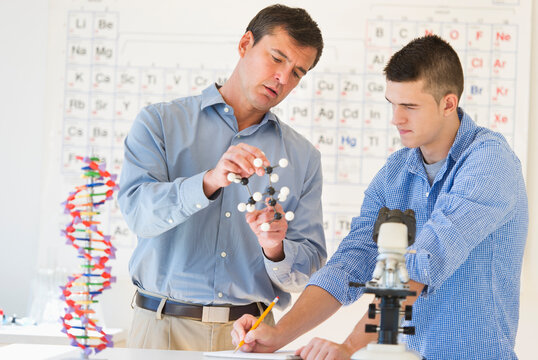 Teacher and teenage (16-17) student in chemistry lab
