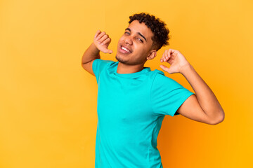 Young african american curly man isolated on purple stretching arms, relaxed position.