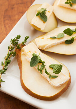 Studio shot of sliced pear with herbs
