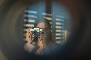 The photographer takes pictures with a retro camera. A look through the lens concept - 410279735