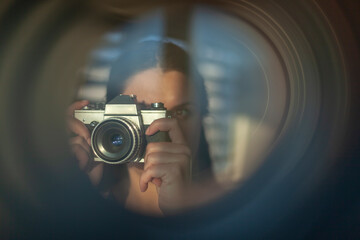 The photographer takes pictures with a retro camera. A look through the lens concept - 410279785