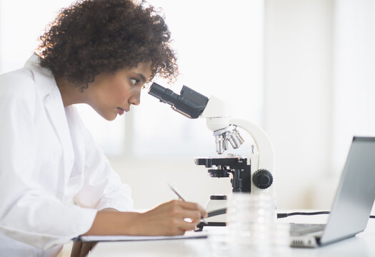 Woman using microscope in laboratory