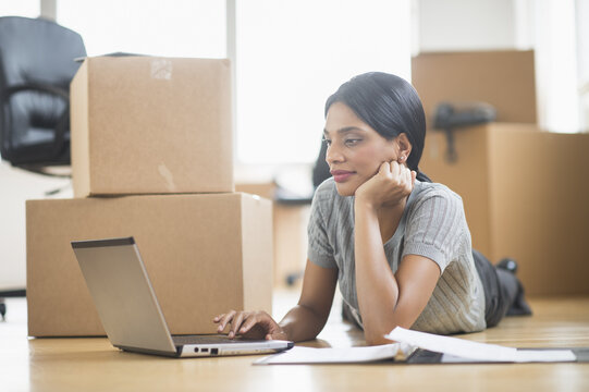 Businesswoman using laptop in new office