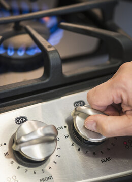 Close-up of hand adjusting stove burner