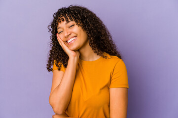 Young african american afro woman isolated laughs happily and has fun keeping hands on stomach.