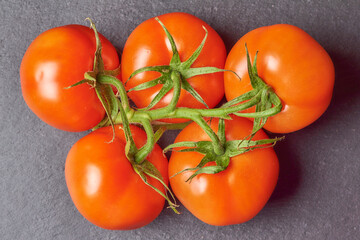 A branch of tomatoes on a black board