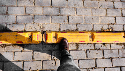 Man boot on the yellow street border with red reflection and cobblestone street in golyazi.