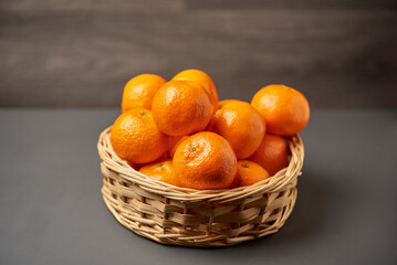 Basket with tangerines on a dark background
