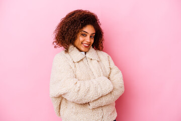 Young african american woman isolated on pink background who feels confident, crossing arms with determination.