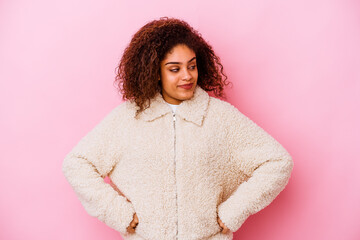 Young african american woman isolated on pink background dreaming of achieving goals and purposes