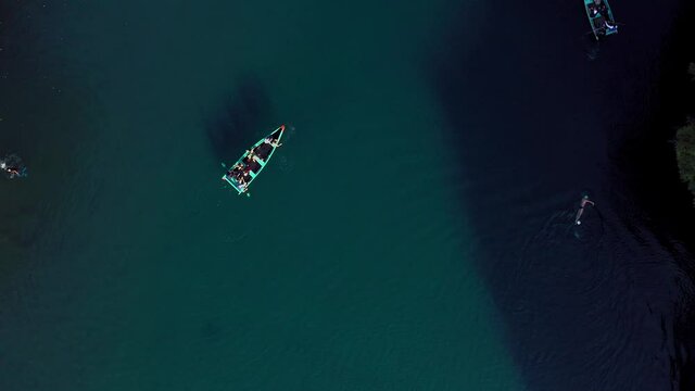 Aerial: swimmer and boats in the lake, drone view