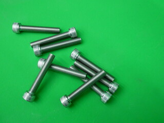 new long metal nut on green background.
