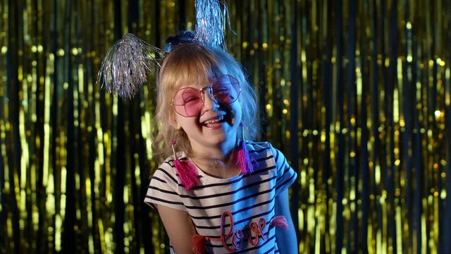 Portrait of fashion, gorgeous girl in futuristic night club with blue neon lights laughing at loud. Trendy stylish child kid smiling cheerfully. Cyberpunk style sensual look clubber alone, slow motion