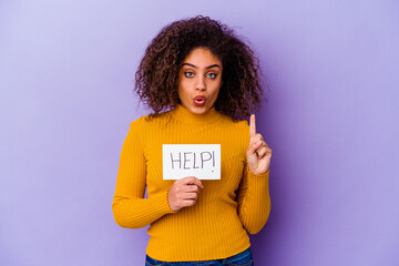 Young African American woman holding a Help placard isolated on purple background having some great idea, concept of creativity.