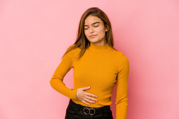Obraz premium Young skinny caucasian teenager girl touches tummy, smiles gently, eating and satisfaction concept.