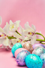 Easter eggs and orchid flower on a pink backdrop. Happy easter food and decorations, Orthodox easter celebration, spring theme, happy easter festive food  