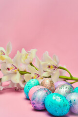 Easter eggs and orchid flower on a pink backdrop. Happy easter food and decorations, Orthodox easter celebration, spring theme, happy easter festive food  