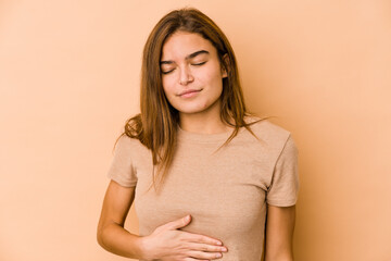 Obraz premium Young skinny caucasian teenager girl touches tummy, smiles gently, eating and satisfaction concept.