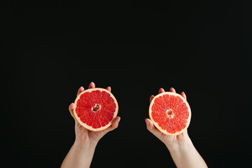 fresh halved grapefruit in woman hands