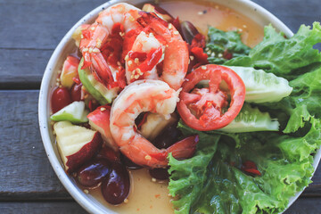 Spicy Thai fruit salad with Shrimps on wooden table at cafe , Thai spicy style healthy food Thai cuisine.