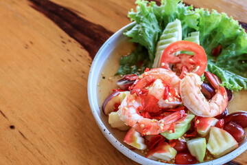 Spicy Thai fruit salad with Shrimps on wooden table at cafe , Thai spicy style healthy food Thai cuisine.