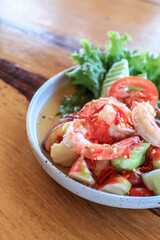 Spicy Thai fruit salad with Shrimps on wooden table at cafe , Thai spicy style healthy food Thai cuisine.