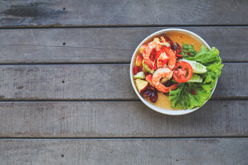 Spicy Thai fruit salad with Shrimps on wooden table at cafe , Thai spicy style healthy food Thai cuisine.