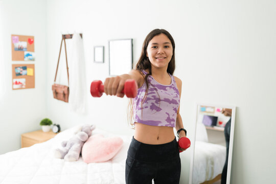 Portrait of an active adolescent smiling and using weigths