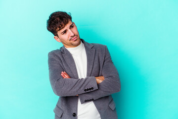 Young caucasian man isolated on blue background dreaming of achieving goals and purposes