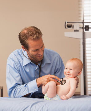Pediatrician listening heartbeat of baby boy (2-5 months)