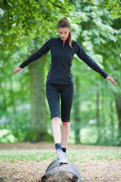 Young woman balancing on log
