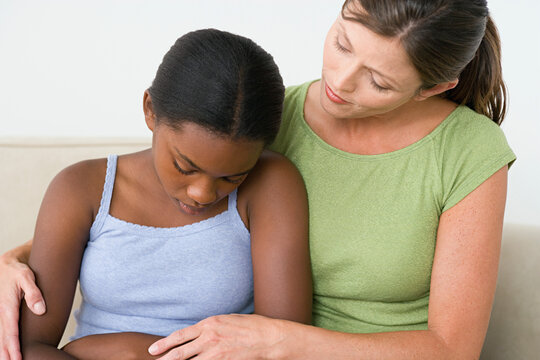 Woman consoling sad girl (10-11)